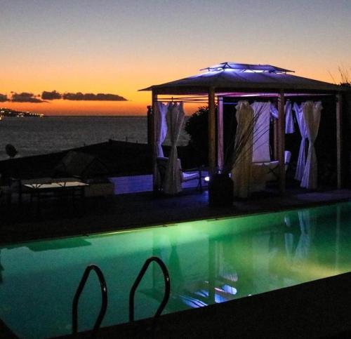 a swimming pool with a gazebo with the sunset at FINTUPS SPA in Viña del Mar