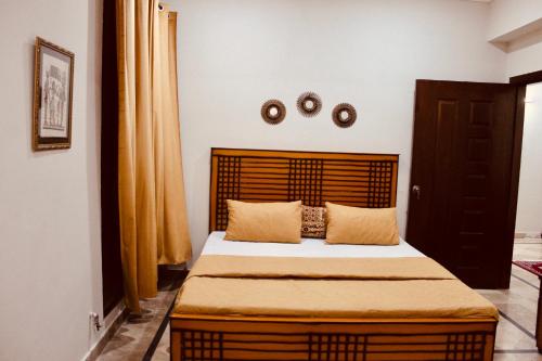 a bedroom with a large bed with a wooden headboard at Islamabad Holiday Appartments One & Two Bed A Perfect Winter Escape to Murree, Northern Areas & Beyond in Islamabad