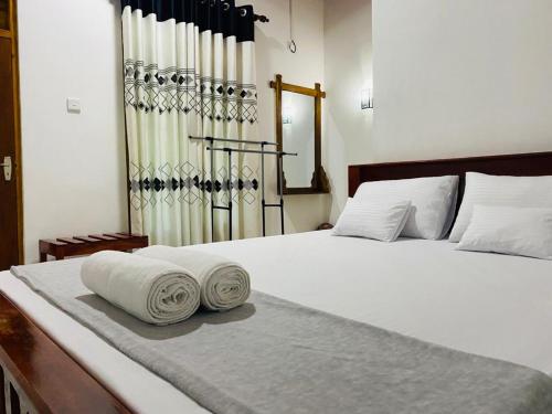 a white bed with towels on top of it at Black Panther Yala in Tissamaharama