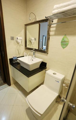 a bathroom with a toilet and a sink and a mirror at CityBay Palace Hạ Long Hotel in Ha Long