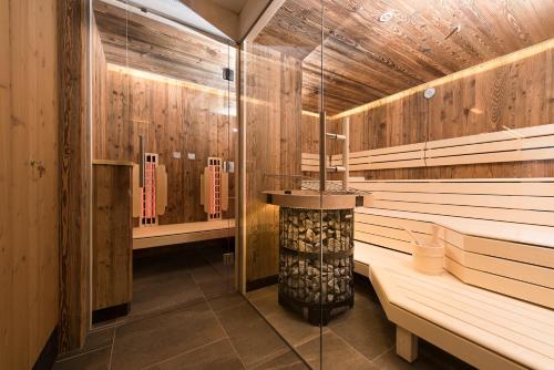 a sauna with a heater in the middle at Hotel Birkenhof in Saalbach Hinterglemm