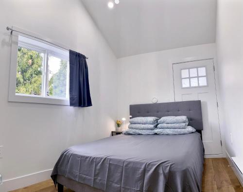 Vancouver’s Homey Laneway House في فانكوفر: غرفة نوم عليها سرير بثلاث مخدات