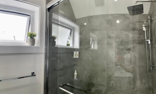 een badkamer met een douche en een glazen deur bij Vancouver’s Homey Laneway House in Vancouver