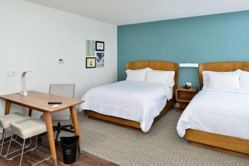 a hotel room with two beds and a desk at Element North Kansas City in Kansas City