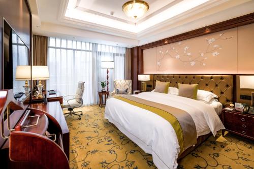 イ坊市にある潍坊富华大酒店a座の大きなベッドとデスクが備わるホテルルームです。