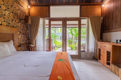 a bedroom with a large bed and a large window at Green Asri Hotel in Senggigi 