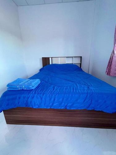 a bed with a blue comforter in a bedroom at Aviator Club in Ban Khong Krathin