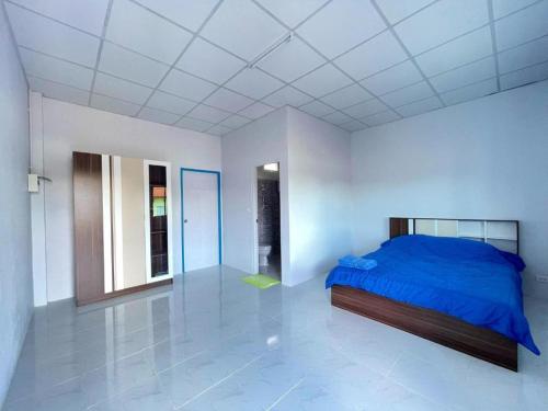 a bedroom with a blue bed in a white room at Aviator Club in Ban Khong Krathin