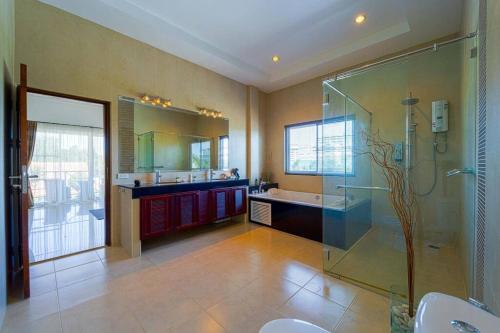 La salle de bains est pourvue d'une douche en verre et d'un lavabo. dans l'établissement Luxurious 5-Bedroom Private Pool Villa! PV5, à Hua Hin