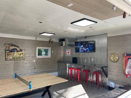 a bar with red stools and a table in a room at Square Toe's Last Resort in New Buffalo