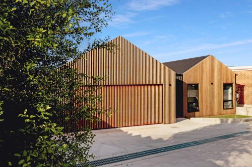 a wooden building with a fence in front of it at Scandinavian beach house! in Port Lincoln