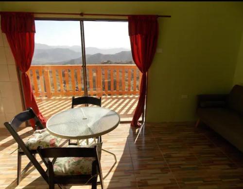 ビクーニャにあるCabaña equipada a 300 metros del observatorio mamallucaのバルコニー付きの客室で、テーブルと椅子が備わります。