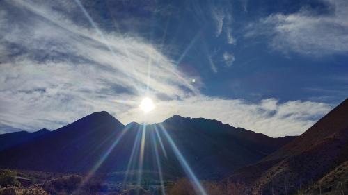 un sol brilla en una montaña en el cielo en Cabaña equipada a 300 metros del observatorio mamalluca, en Vicuña