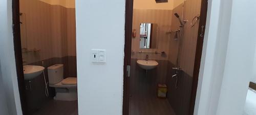 ein Badezimmer mit einem WC, einem Waschbecken und einem Spiegel in der Unterkunft Khách sạn 68 ĐỒNG HẢI in Dong Hoi