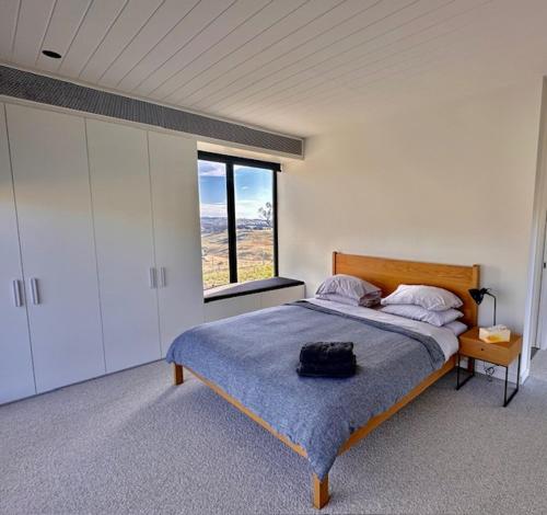 Un dormitorio con una cama con una bolsa. en Spectacular Kangaroobie Cabin en Borenore
