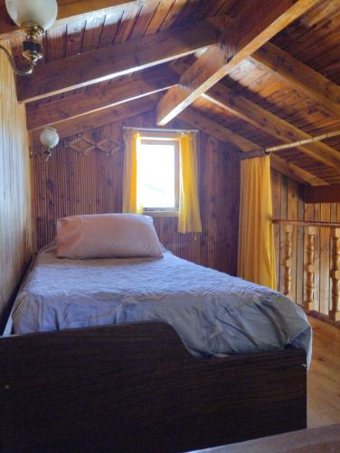 una camera con un letto in una stanza con una finestra di Cabañas Camahueto a Licán Ray
