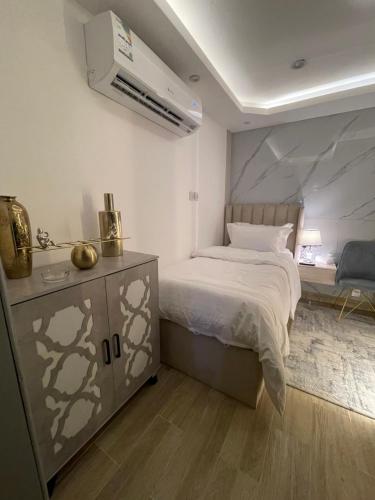 een slaapkamer met een bed en een dressoir met een bed. bij Riyadh Single Studio in Riyad
