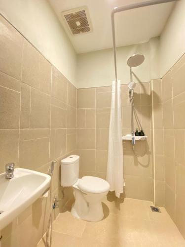 a bathroom with a toilet and a sink at Maluk Stay in Maluk