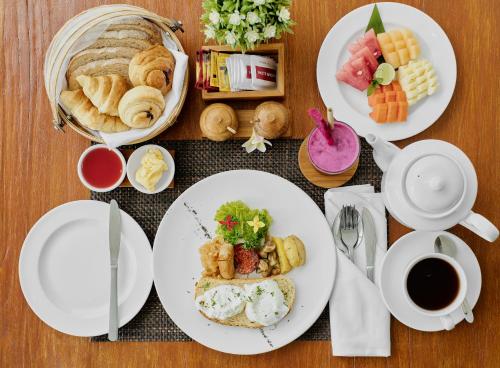 a table with plates of breakfast foods and a cup of coffee at Van Sheva Ubud Villa in Ubud