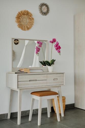 a desk with a vase of flowers and a mirror at Van Sheva Ubud Villa in Ubud
