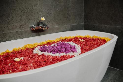 a bath tub full of flowers in a bathroom at Van Sheva Ubud Villa in Ubud