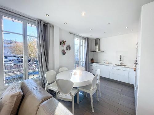 une cuisine et une salle à manger avec une table et des chaises blanches dans l'établissement Cannes Heart of town 2 BR perfect congress & Holidays by Olam Properties, à Cannes