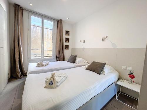 deux lits dans une chambre avec une fenêtre dans l'établissement Cannes Heart of town 2 BR perfect congress & Holidays by Olam Properties, à Cannes
