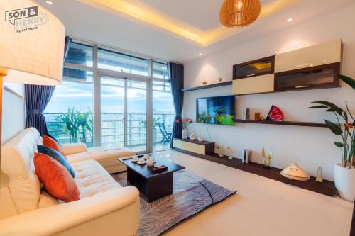 a living room with a white couch and a large window at Son&Henry Sailing Tower in Ho Chi Minh City