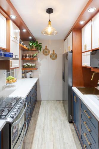 a kitchen with blue cabinets and a stainless steel refrigerator at Casa Ramos Salamanca - Airport pick up and drop off service - Homestay in Lima