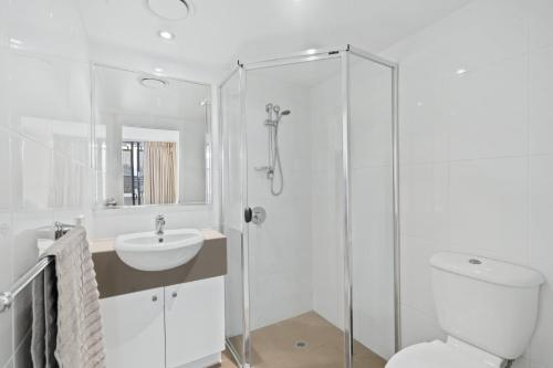 y baño con aseo, lavabo y ducha. en Modern 2BR Apt next to SouthBank Free Wifi & Pool en Brisbane