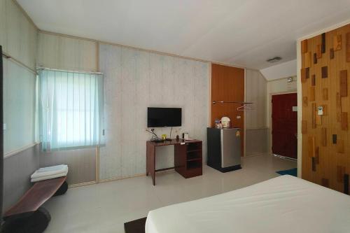 a hotel room with a bed and a television at The Creek Resort in Ban Rai