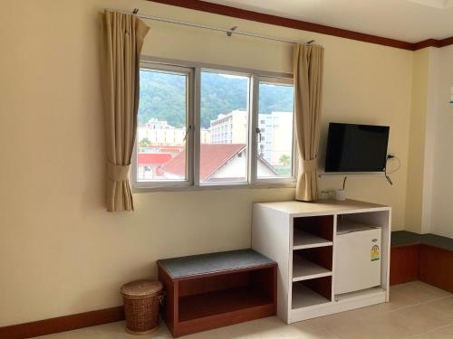 sala de estar con TV y ventana en Priew Wan Guesthouse, en Patong Beach