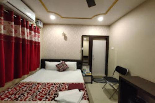 a bedroom with a bed and a red curtain at Hotel Holiday inn , Kanakpur in Silchar