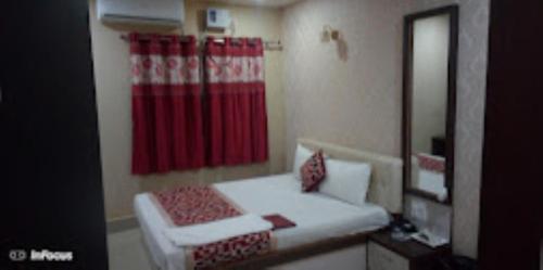 a bedroom with a red shower curtain and a bed at Hotel Holiday inn , Kanakpur in Silchar