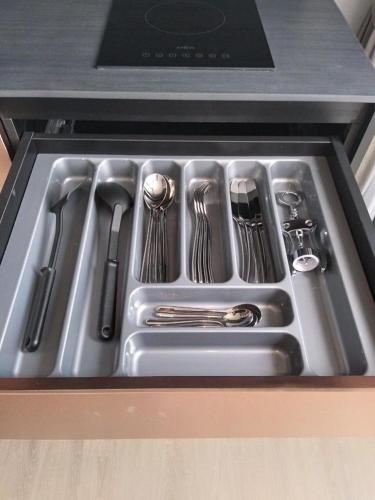 a stainless steel sink with utensils in a drawer at Condo Edge Central in Pattaya Central