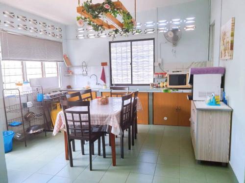 Syukur Homestay Ipoh في ايبوه: مطبخ مع طاولة وكراسي في غرفة