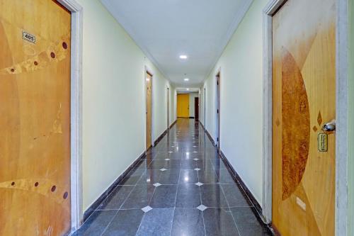 um corredor vazio com piso em azulejo e uma porta em Collection O chamiers park em Chennai