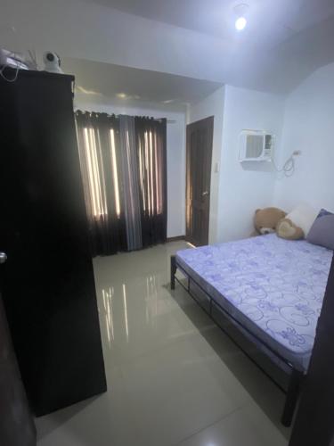- une chambre avec un lit bleu dans l'établissement Fionas Apartment, à Manille