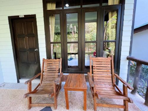 2 Holzstühle und ein Holztisch auf einer Veranda in der Unterkunft Dream Valley Resort, Tonsai Beach in Tonsai Beach