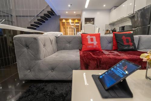a living room with a gray couch with red pillows at Luks Lofts Hotel & Residences in Batangas City