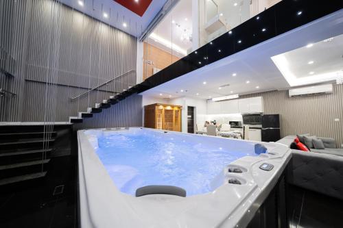 bañera grande en una habitación con sofá en Luks Lofts Hotel & Residences en Batangas
