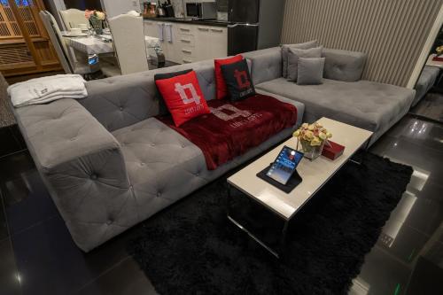 a living room with a gray couch with red pillows at Luks Lofts Hotel & Residences in Batangas City