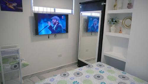 a room with a television on a wall with a bed at Apartaestudio Vista azul rodadero Mara 502 in Santa Marta