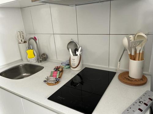 um balcão de cozinha com um lavatório e utensílios em horizon suite 25-11 em Sepang