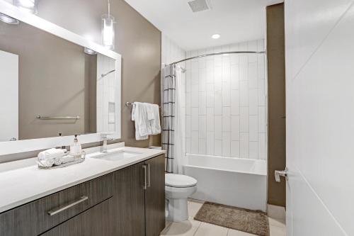 uma casa de banho com um lavatório, um WC e um chuveiro em Sunset Views from a Stylish 1BR High Rise in Tampa em Tampa