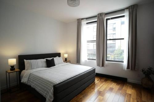 1 dormitorio con 1 cama grande y 2 ventanas en HRésidences Modern Condo on MAIN St Laurent Blvd, en Montreal
