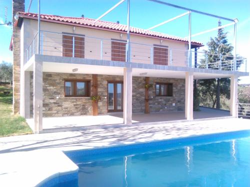 a house with a swimming pool in front of it at Casa das Argolas in Macedo de Cavaleiros