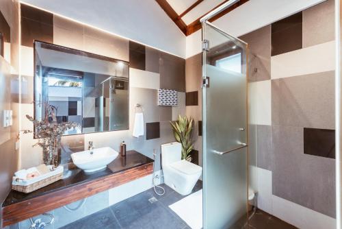 a bathroom with a sink and a toilet and a shower at ALON CLOUD9, beach front in Catangnan