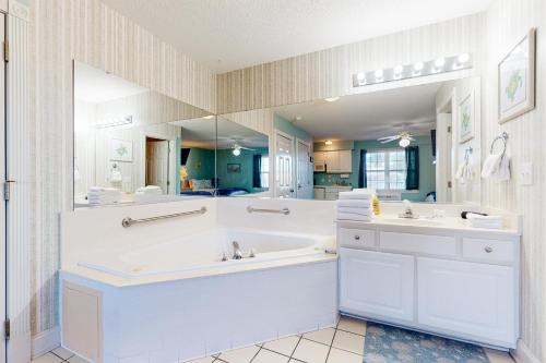 een badkamer met 2 wastafels en een grote spiegel bij Golf n' Sea B in Calabash