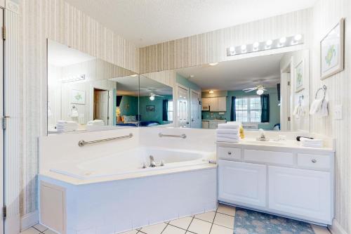 a bathroom with two sinks and a large mirror at Golf n' Sea B in Calabash